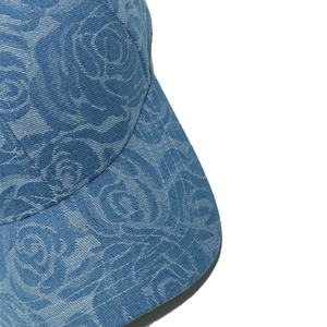 Detail of rose floral pattern on denim baseball cap with white reinforced stitching
