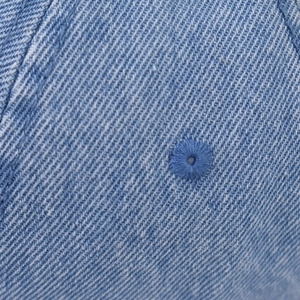 Makrodetail der gewaschenen blauen Denim-Struktur mit hochwertigem gesticktem Luftloch