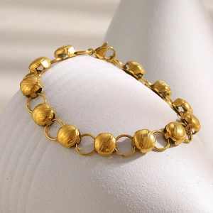 Detailansicht eines 18K vergoldeten Perlenarmbandes mit Texturen und Karabinerverschluss