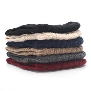 Detail view of colorful knitted beanies showing soft thick textures and warm folded layers