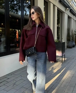 Gros plan d'un manteau en laine bordeaux avec revers élégant et fermeture éclair