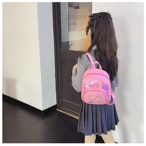 Détail d'un sac à dos sirène à paillettes roses montrant l'ajustement sur le dos d'un enfant