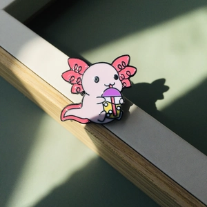 Broche mignonne en émail axolotl rose tenant un bubble tea avec couvercle violet en métal