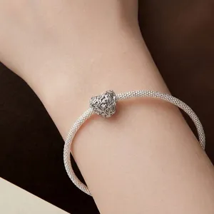 Braided silver S925 bracelet featuring a heart pendant with vintage leaf carvings on wrist