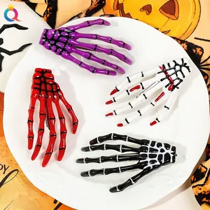 Detail showing four skeleton hand hair clips in purple, red, white, and black for Halloween