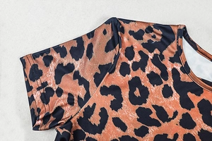 Detailed close-up of leopard print fabric with precise stitching on round neckline and sleeves