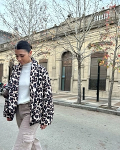 Chic leopard print quilted jacket with side view of a model walking outdoors
