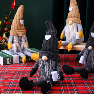 Primer plano de gnomos navideños de peluche hechos a mano con gorros de punto y tazas