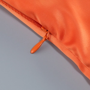 Detail of high-quality orange halter dress with matching invisible zipper and metal slider