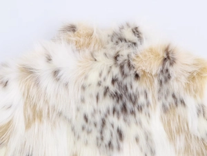 Close-up detail of soft faux fur texture with elegant white and brown spotted pattern