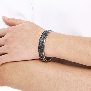 Detail of Viking Valknut symbol and geometric patterns on a vintage silver bangle