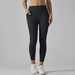 Detailopname van een zwarte yoga broek met hoge taille, zijzak en gladde elastische stof
