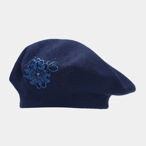 Dettaglio del basco in maglia blu navy con ricami floreali 3D e strass scintillanti