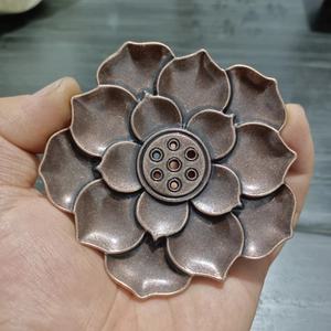 Close-up of bronze lotus incense burner showing layered petals and six center holes