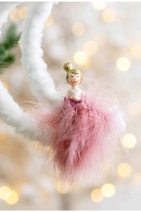 Detail of pink feather skirt ballet girl ornament with warm bokeh holiday background