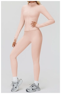 Close-up of pink fitness set featuring high waist yoga pants and thumb hole cuff detail