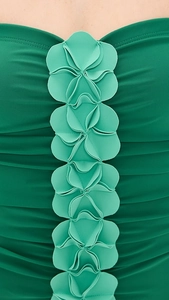 Detail view of 3D floral embellishments and ruched texture on mint green swimwear