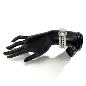 Detailed view of triple-layer pearl bracelet with a large rectangular crystal centerpiece