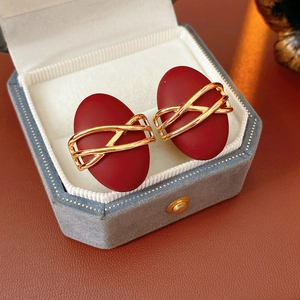 Detail shot of vintage oval stud earrings with deep red finish in a luxury jewelry box