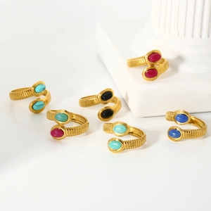 Detail of 18k gold plated wave rings with colorful oval natural stones on stone pillars
