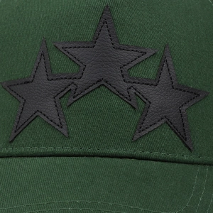 Detailed close-up of three black leather star patches stitched on a green trucker cap