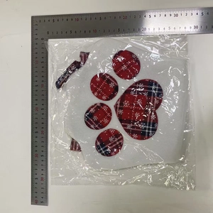 Flat lay macro of a dog paw Christmas stocking in plastic packaging with measurement ruler