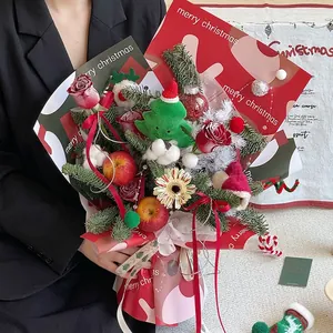 Christmas bouquet with red roses, apples and pine needles in festive holiday paper