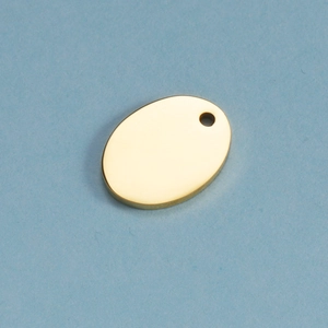 Macro shot of oval gold polished stainless steel pendant charm on light blue background