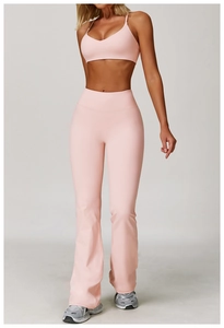 Dettaglio dei pantaloni yoga a zampa e top sportivo rosa in tessuto opaco spazzolato