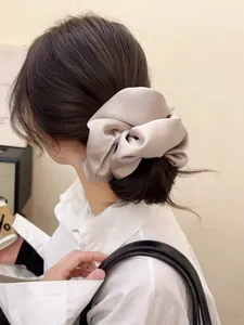 Detailed view of oversized champagne satin scrunchie on hair showing soft silk texture