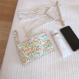 Floral cotton mini phone bag with pink and green patterns on a quilted surface