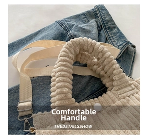 Detail of beige corduroy bucket bag with pleated handle and adjustable canvas strap