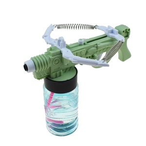 Detail of green crossbow style bubble gun toy with transparent liquid bottle and spring