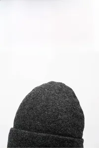Close-up of deep gray knitted beanie texture with a ribbed fold-over cuff design
