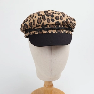 Detail of leopard print military cap with black brim and decorative braided rope trim