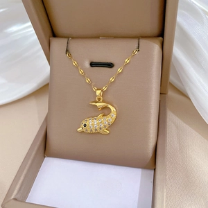 Elegant gold titanium dolphin necklace with crystal pavé in a beige jewelry box
