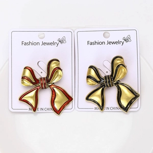 Detail of red and black enamel bow brooches in gold finish on jewelry display cards
