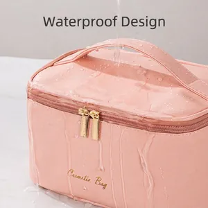 Pink waterproof cosmetic bag with double zipper and handle shown under water flow splash