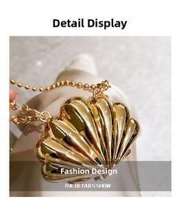 Detailed close-up of shell-shaped golden mini bag with metallic texture and bead chain