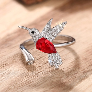 Macro-opname van kolibri-ring met rode peervormige steen en zirkonia-details