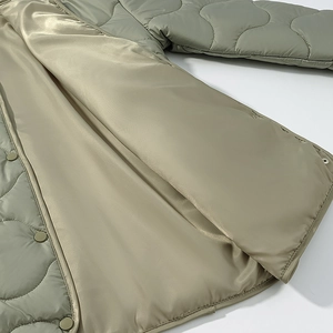 Detail of wavy quilted jacket with sage green shell and champagne satin lining