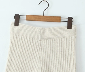Detail einer cremefarbenen Rippstrickhose mit hoher Taille und vertikaler Texturierung