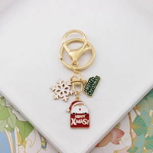 Close-up of golden Christmas keychain with Santa Claus, snowflake and Merry Christmas tag