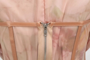 Macro view of pink mesh dress featuring concealed back zipper and boning structure detail