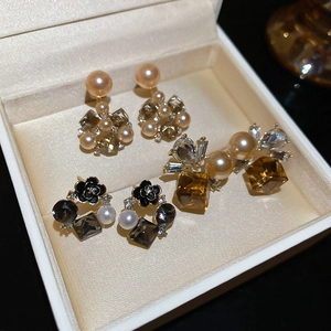 Dettaglio di tre paia di orecchini vintage con perle e cristalli in una scatola regalo