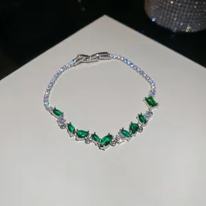 Gros plan détaillé d'un bracelet de tennis argenté orné de zircons vert émeraude