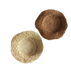 Handcrafted crochet straw sun hat with wavy scalloped brim in beige and caramel tones