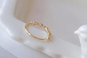 Macro shot of gold-plated stacking ring with freshwater pearls and cubic zirconia