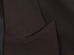 Détail de la texture du blazer marron foncé avec couture du col croisé