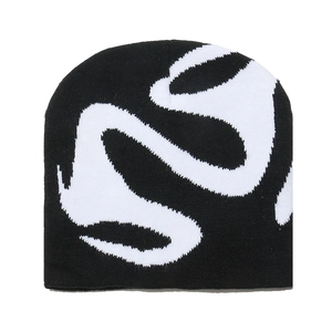 Detail of black and white knitted beanie with high-contrast abstract wave pattern texture